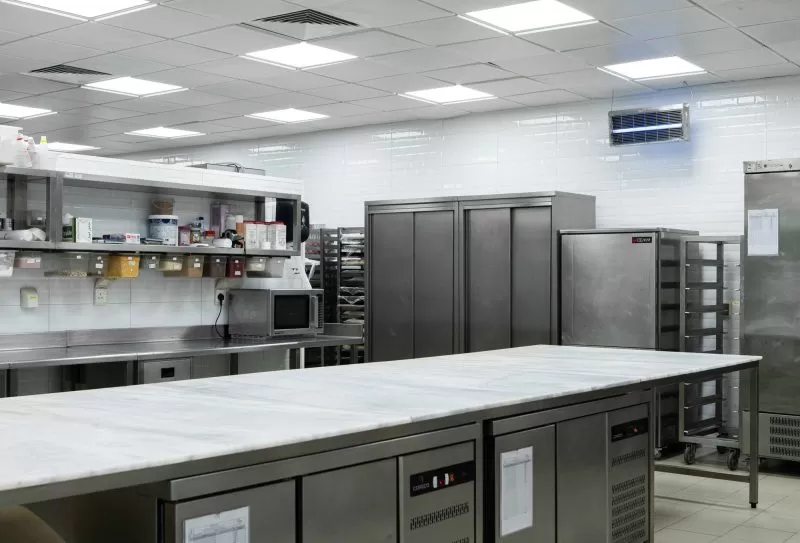 Main floor of the Plum central kitchen with a marble island and stainless work stations